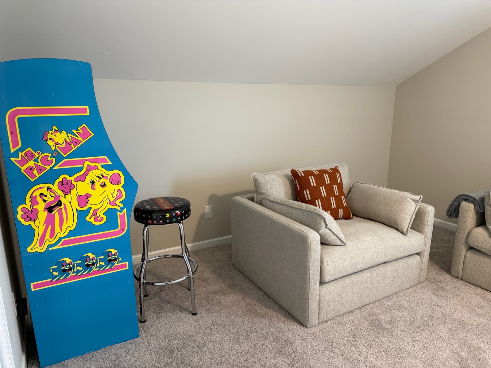 Arcade cabinet and lounge chair in the game room